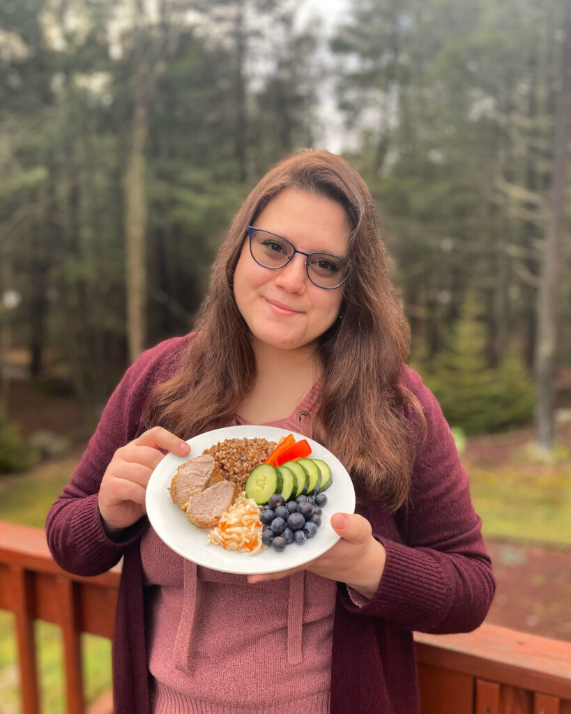 Dietitian A. Boyd holding a colorful plate of foods.